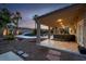 Outdoor view of the backyard with a pool and covered patio featuring stone flooring and comfortable seating arrangements at 6245 Galileo Dr, Las Vegas, NV 89149