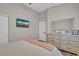 Relaxing bedroom with soft lighting, light-colored decor, a wall-mounted TV, and a large dresser with a mirror at 6245 Galileo Dr, Las Vegas, NV 89149