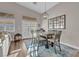 The open dining area features a modern chandelier, views of the backyard, and seating for four at 6245 Galileo Dr, Las Vegas, NV 89149