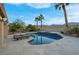 Relaxing backyard pool with waterfall feature, surrounded by palm trees and desert landscaping at 6245 Galileo Dr, Las Vegas, NV 89149