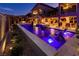 Backyard at dusk with a pool, spa, fire pit and outdoor seating areas at 6570 Aurora View St, Las Vegas, NV 89135