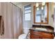 Cozy bathroom with a decorative mirror, dark countertop vanity and shower with a patterned curtain at 6570 Aurora View St, Las Vegas, NV 89135