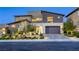 Inviting modern home featuring a two-car garage, complemented by lush, professionally landscaped greenery at 6570 Aurora View St, Las Vegas, NV 89135