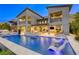 Beautiful two-story home exterior featuring a pool, patio, balcony, and outdoor seating areas at 6570 Aurora View St, Las Vegas, NV 89135
