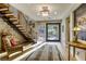 Inviting foyer with a floating staircase and a decorative rug on light hardwood flooring at 6570 Aurora View St, Las Vegas, NV 89135