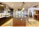 Spacious kitchen boasting dark wood cabinetry, large island with bar seating, and stainless steel appliances at 6570 Aurora View St, Las Vegas, NV 89135