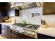 Modern kitchen with stainless steel range hood, gas range, and white subway tile backsplash at 6570 Aurora View St, Las Vegas, NV 89135