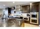 Gourmet kitchen featuring stainless steel appliances, a tile backsplash, and stone countertops at 6570 Aurora View St, Las Vegas, NV 89135