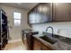 Well-organized laundry room with modern washer and dryer, ample counter space, and dark cabinets at 6570 Aurora View St, Las Vegas, NV 89135