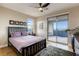 Bright main bedroom featuring a ceiling fan, balcony access, and a comfortable black wood bed frame at 6570 Aurora View St, Las Vegas, NV 89135