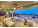 Spacious covered patio featuring comfortable seating, ceiling fans, and views of the pool and backyard at 6570 Aurora View St, Las Vegas, NV 89135