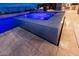 Inviting spa with blue lighting and stone surround with backyard views at 6570 Aurora View St, Las Vegas, NV 89135
