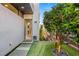Modern home entrance featuring a well-manicured garden with artificial turf and stone walkway leading to the front door at 671 Scenic Rim Dr, Henderson, NV 89012