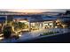 Striking modern home with sleek architecture and a well-manicured front yard, offering captivating city views at sunset at 671 Scenic Rim Dr, Henderson, NV 89012