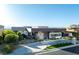 Beautiful modern home with distinct architectural lines, complemented by lush landscaping and mature trees at 671 Scenic Rim Dr, Henderson, NV 89012