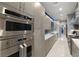 Modern kitchen showcasing stainless steel appliances and sleek cabinetry with a long countertop and tile floors at 671 Scenic Rim Dr, Henderson, NV 89012