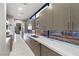 Modern kitchen with sleek gray cabinets, white countertops, long windows, and stainless steel appliances at 671 Scenic Rim Dr, Henderson, NV 89012