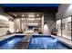 Luxury home boasts an eye-catching indoor-outdoor pool area with sophisticated decor and comfortable seating at 671 Scenic Rim Dr, Henderson, NV 89012