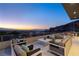 Expansive outdoor terrace features multiple seating areas, a barbecue grill, and stunning views of the cityscape and mountains at 671 Scenic Rim Dr, Henderson, NV 89012