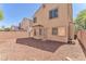 Exterior view of the back of the house with rock landscaping, privacy wall and mature landscaping at 7621 Breed Hill St, Las Vegas, NV 89149