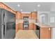 Well-lit kitchen featuring wood cabinets, granite countertops, and modern black appliances at 7621 Breed Hill St, Las Vegas, NV 89149