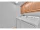 Functional laundry room with washer, dryer, and upper cabinets for storage at 7621 Breed Hill St, Las Vegas, NV 89149