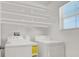Bright laundry room features new appliances and ample shelving for storage at 8949 Merry Mullion Ct, Las Vegas, NV 89149