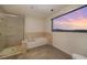 Bright bathroom featuring a shower, tub, and large window showcasing mountain views at 900 Las Vegas Blvd # 912, Las Vegas, NV 89101