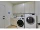 Functional laundry room with a sink, modern washer and dryer, and custom cabinetry at 9425 Villa Ridge Dr, Las Vegas, NV 89134