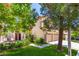 Charming home exterior featuring a well-manicured lawn, mature trees, and a two-car garage at 9440 Grenville Ave, Las Vegas, NV 89134