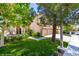 Charming home exterior featuring a well-manicured lawn, mature trees, and a two-car garage at 9440 Grenville Ave, Las Vegas, NV 89134
