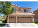 Charming two-story home with a three-car garage and desert landscaping against a clear blue sky at 9440 Grenville Ave, Las Vegas, NV 89134