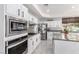 Modern kitchen featuring white cabinets, stainless steel appliances, and a granite countertops at 9440 Grenville Ave, Las Vegas, NV 89134