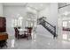 Spacious living room with soaring ceilings, large windows, and an elegant staircase at 9440 Grenville Ave, Las Vegas, NV 89134