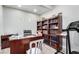Home office with wood desk, bookcase, laminate wood flooring, and treadmill at 9440 Grenville Ave, Las Vegas, NV 89134