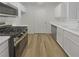 Clean kitchen features stainless steel appliances, white cabinets, durable countertops and wood-look flooring at 950 Seven Hills Dr # 217, Henderson, NV 89052