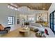 Open-concept living room showcasing a curved couch, modern decor, and light hardwood floors and vaulted wood-lined ceiling at 9520 Sundial Dr, Las Vegas, NV 89134