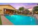 Lush backyard featuring a sparkling pool, covered seating, and an outdoor kitchen, perfect for entertaining at 9685 Stonily Ln, Las Vegas, NV 89178