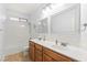 Bright bathroom featuring double sinks, tile floors, a shower-tub combo, and white cabinets at 9685 Stonily Ln, Las Vegas, NV 89178