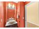 Stylish powder room with a vessel sink and warm, inviting coral walls, adjacent to another room at 9685 Stonily Ln, Las Vegas, NV 89178