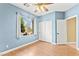 Bedroom featuring wood floors, light blue paint, a closet, and a window with curtains at 9685 Stonily Ln, Las Vegas, NV 89178