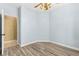 Bright bedroom featuring wood-look floors, light blue walls, ceiling fan, and an open closet at 9685 Stonily Ln, Las Vegas, NV 89178