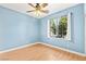 Light blue bedroom featuring wood floors, a ceiling fan, window with curtains, and white baseboards at 9685 Stonily Ln, Las Vegas, NV 89178