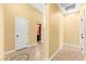 Hallway featuring neutral walls, tile flooring, and white trim leading to a room with red accent paint at 9685 Stonily Ln, Las Vegas, NV 89178