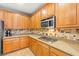 Kitchen area featuring wooden cabinets, tile floors, and stone countertops at 9685 Stonily Ln, Las Vegas, NV 89178