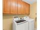 Efficient laundry area with modern washer and dryer, plus upper cabinets for ample storage at 9685 Stonily Ln, Las Vegas, NV 89178