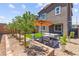 A backyard with a neat patio set under an umbrella, blooming trees along the fence, and a mix of grass and gravel at 9743 Mojave Mountain St, Las Vegas, NV 89166