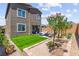 A well-manicured backyard features green grass, mature trees, a cozy patio set, and a surrounding brick-lined garden at 9743 Mojave Mountain St, Las Vegas, NV 89166
