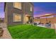 Backyard featuring a well-maintained lawn and a patio with outdoor seating beneath an umbrella at 9743 Mojave Mountain St, Las Vegas, NV 89166