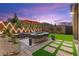 Tranquil backyard with ambient lighting, stylish patio furniture, and well-manicured landscaping for evening relaxation at 9743 Mojave Mountain St, Las Vegas, NV 89166